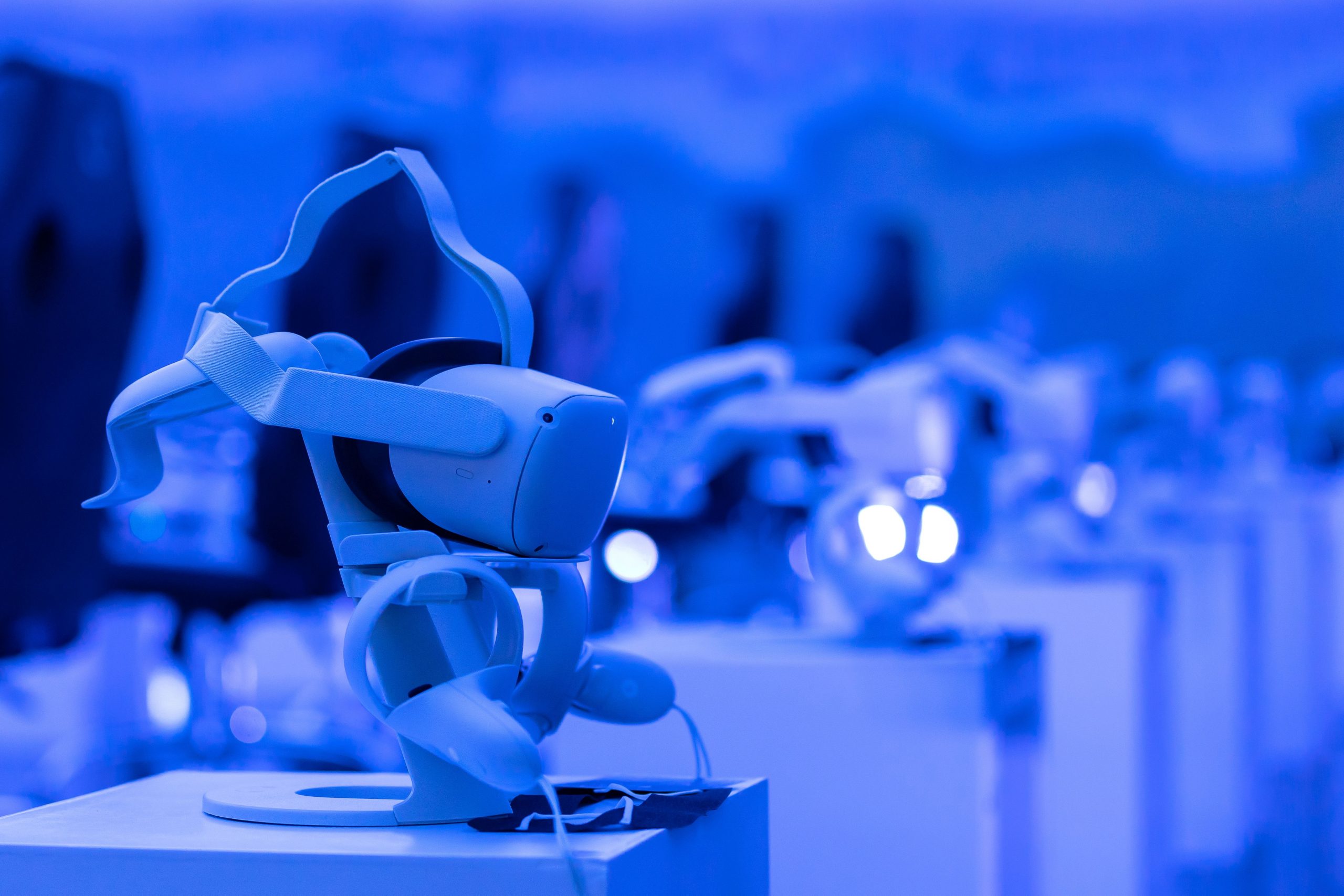 Visor de realidad virtual sobre un pedestal en un espacio tecnológico iluminado en azul, representando herramientas inmersivas para formación creativa.